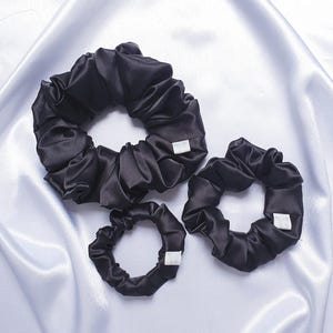 Black silky satin scrunchies available in 3 sizes:
Approximate Sizes:
XXL - 6 inches in diameter
Medium -4 inches in diameter
Mini - 3 inches in diameter