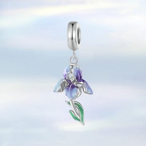 May include: A silver charm featuring a purple and blue iris flower with green leaves. The charm has a loop at the top for attaching to a bracelet or necklace.