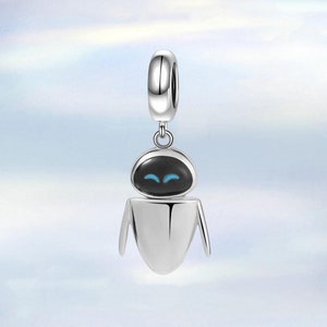 May include: Silver charm featuring a robot character with a black head and blue eyes. The robot has a silver body and arms. The charm has a loop at the top for attaching to a bracelet or necklace.