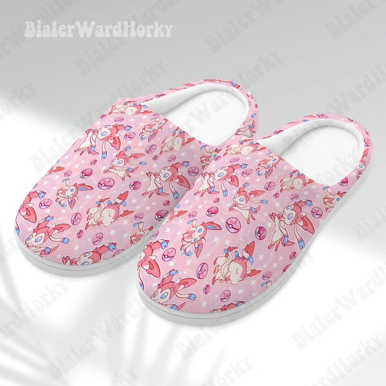 Może przedstawiać: Biały ceramiczny kubek z czarnym uchwytem i napisem "But First, Coffee" w stylu odręcznym. Kubek stoi na białej powierzchni. Kubek ma około 10 cm wysokości.