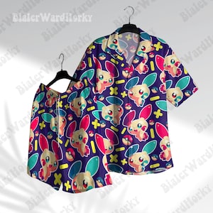 Könnte beinhalten: Ein zweiteiliger Schlafanzug in Lila, bestehend aus einem kurzärmeligen Hemd und Shorts. Das Set ist mit einem sich wiederholenden Muster eines Cartoon-Charakters in Rosa, Blau, Gelb und Weiß bedruckt. Das Hemd hat einen Kragen und Knöpfe, die Shorts einen Kordelzug.