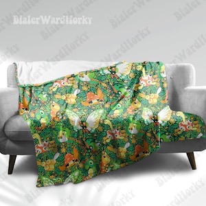 May include: A green blanket with a repeating pattern of colorful cartoon creatures, butterflies, and foliage. The blanket is draped over a gray sofa.