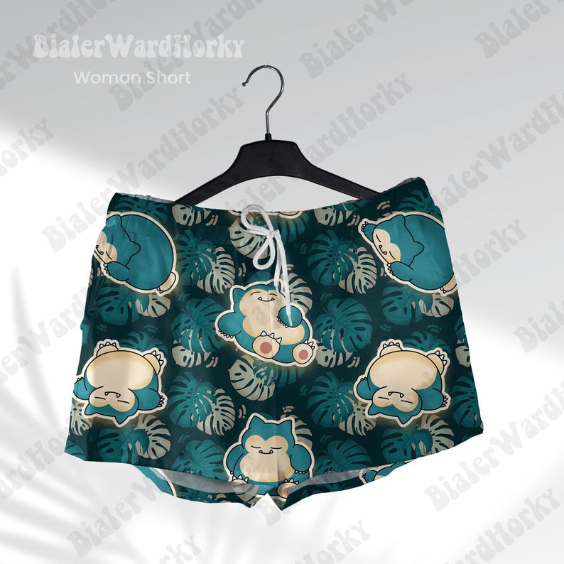 K&ouml;nnte beinhalten: Gr&uuml;n-blaue gemusterte Shorts mit einem Cartoon-Charakter-Design. Die Shorts haben einen Kordelzugbund und eine lockere Passform.