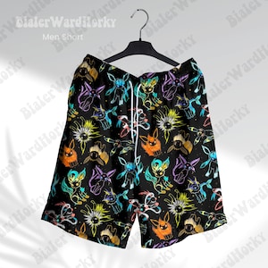 Puede incluir: Shorts negros con un colorido estampado de personajes de dibujos animados. Los shorts tienen cintura con cord&oacute;n y est&aacute;n colgados de una percha negra. El texto "Men Short" es visible en la parte superior de la imagen.