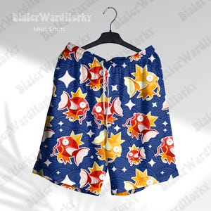 May include: Blue swim trunks with a repeating pattern of orange and yellow cartoon fish on a dark blue background.