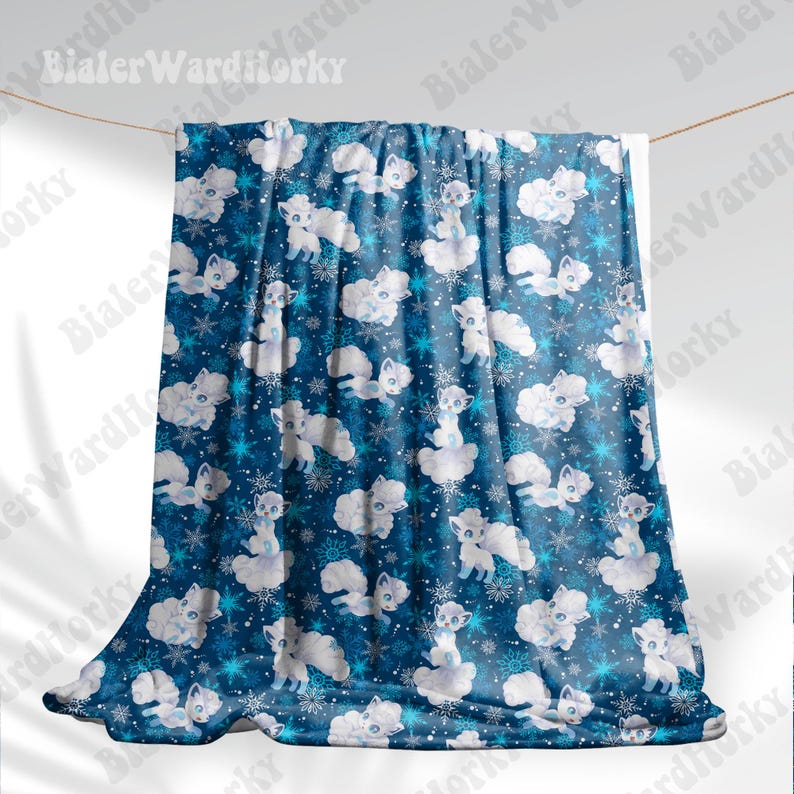 May include: A blue blanket featuring a repeating pattern of white cartoon foxes, clouds, and snowflakes. The blanket is suspended from a washing line. The foxes have fluffy tails and are in different poses.