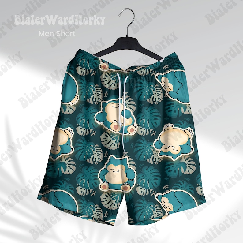 May include: Teal shorts with a repeating pattern of a cartoon character and tropical leaves. The shorts have a drawstring waist and are hanging on a black hanger. The text "Men Short" is visible.