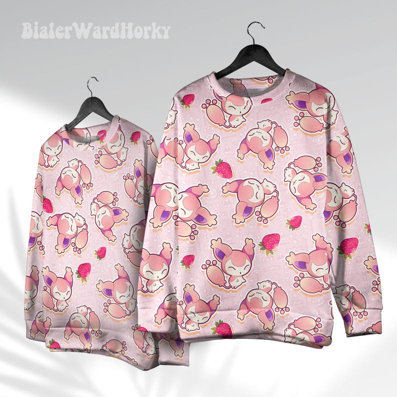 May include: Two light pink sweatshirts with a repeating pattern of cartoon animals and strawberries. The sweatshirts are hanging on black hangers. The text "BialerWardHorky" is in the upper left corner.