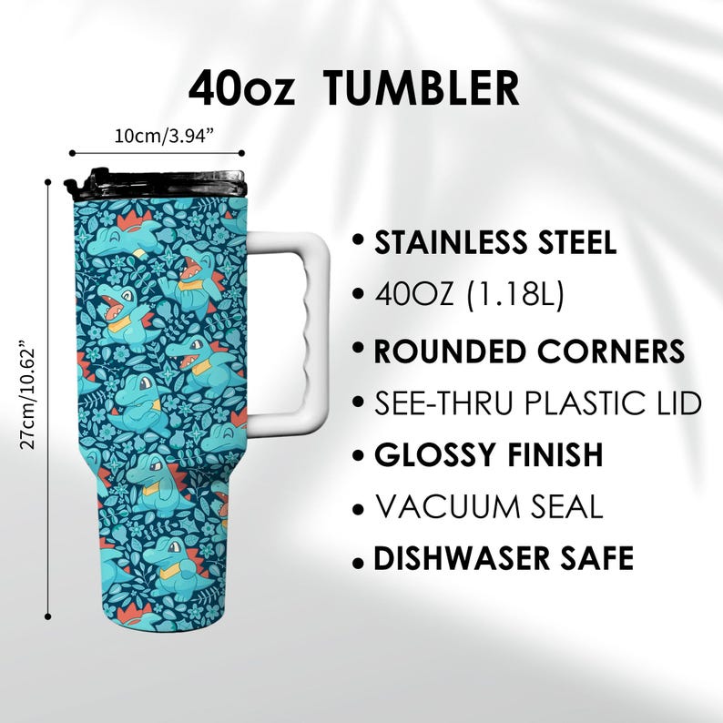 May include: A 40oz tumbler with a blue and green cartoon alligator pattern. The tumbler has a white handle and a black lid. The text "40oz TUMBLER" is at the top. The tumbler is 27cm tall and 10cm wide.