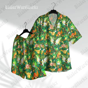May include: A matching green button-up shirt and shorts set. The set features a repeating pattern of colorful cartoon creatures and foliage. The shirt has short sleeves and a collar, while the shorts have a drawstring waist.