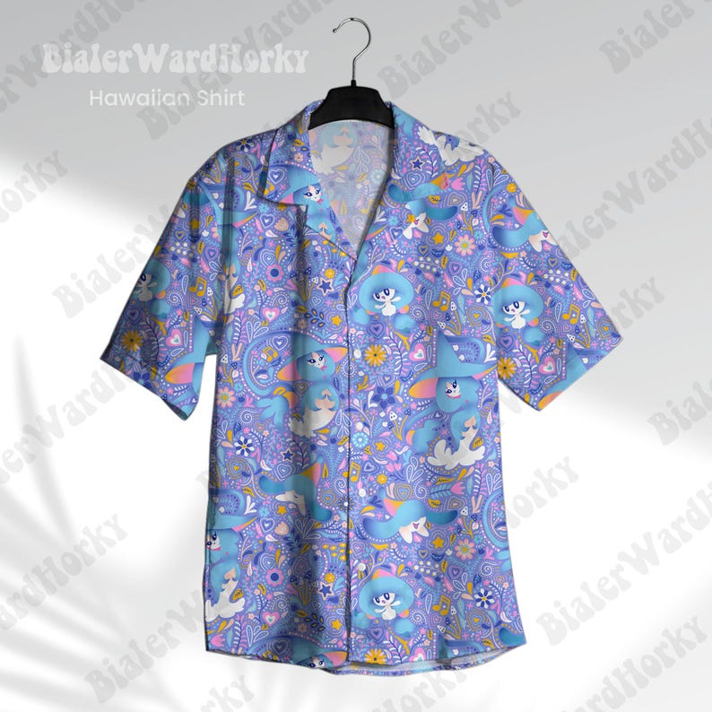 May include: A light blue short-sleeved Hawaiian shirt featuring a playful pattern of cartoon characters, flowers, and paisley motifs. The shirt is suspended from a black hanger. The words "Hawaiian Shirt" are printed on the shirt.