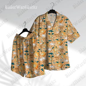 May include: A yellow and orange short-sleeved button-up shirt and matching shorts with a repeating pattern of cartoon dragons and clouds.