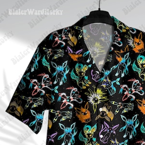 Puede incluir: Camisa negra de manga corta con un estampado colorido de criaturas de dibujos animados. El dise&ntilde;o incluye criaturas en tonos azules, naranjas, amarillos y morados sobre un fondo negro. La camisa tiene cuello cl&aacute;sico y es abotonada.