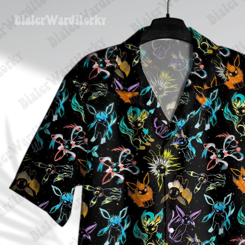 Puede incluir: Camisa negra de manga corta con un estampado colorido de criaturas de dibujos animados. El dise&ntilde;o incluye criaturas en tonos azules, naranjas, amarillos y morados sobre un fondo negro. La camisa tiene cuello cl&aacute;sico y es abotonada.