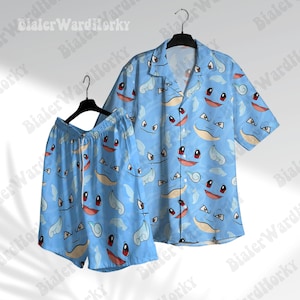 Puede incluir: Conjunto de camisa y pantalón corto azul claro con un estampado repetido de caras de personajes de dibujos animados. La camisa tiene cuello y mangas cortas. El pantalón corto tiene cintura elástica. Ideal para uso casual.