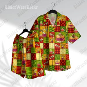 Pode incluir: Um conjunto de pijama vermelho, amarelo e verde estampado, com uma camisa de manga curta abotoada e calções combinando. O padrão apresenta uma variedade de personagens de desenhos animados e designs.