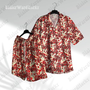 May include: A matching red and white short-sleeve shirt and shorts set. The set features a repeating pattern of cartoon characters on a red background. The shirt has a collared neckline and button-down front. The shorts have a drawstring waist.