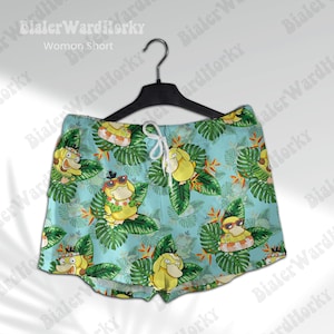 K&ouml;nnte beinhalten: Blaue und gr&uuml;ne gemusterte Shorts mit einem Cartoon-Charakter-Design. Die Shorts haben einen Kordelzugbund und eine lockere Passform.