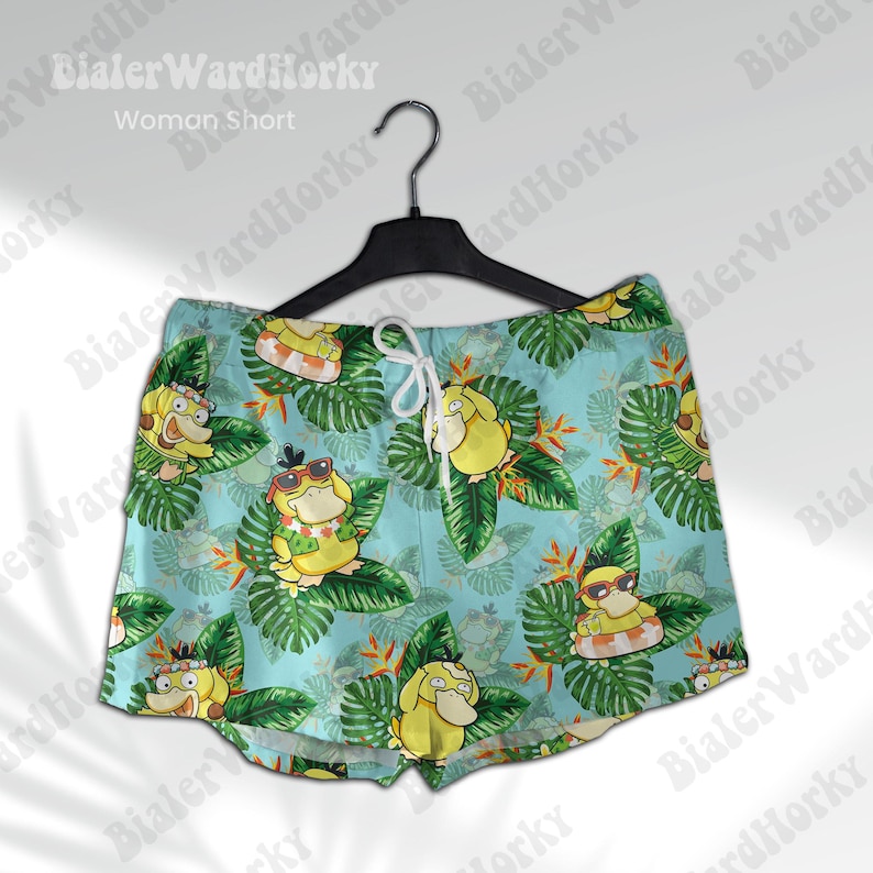 K&ouml;nnte beinhalten: Blaue und gr&uuml;ne gemusterte Shorts mit einem Cartoon-Charakter-Design. Die Shorts haben einen Kordelzugbund und eine lockere Passform.