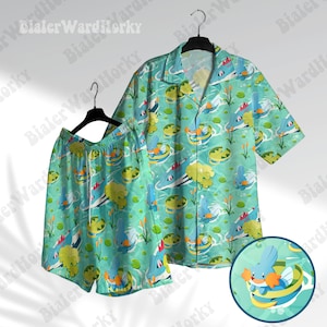 Peut inclure: Un ensemble pyjama bleu et vert à motifs avec un personnage de dessin animé. La chemise a des manches courtes et une fermeture boutonnée à l'avant. Le short a une taille élastique.