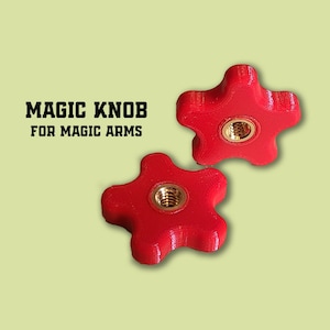 Puede incluir: Dos pomos rojos en forma de estrella con un inserto roscado de latón. Los pomos están etiquetados "MAGIC KNOB FOR MAGIC ARMS".
