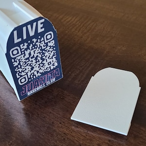 May include: White plastic baseball bat holder with a black and red label that says "LIVE" and "JUANITA BASEBALL CLUB" with a QR code.