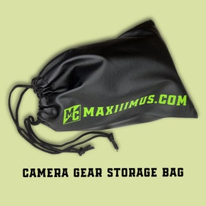 Puede incluir: Bolsa de almacenamiento negra para equipo de cámara con cierre de cordón. La bolsa tiene un logotipo verde que dice "MC MAXIMUS.COM".