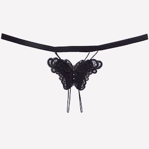 May include: Black lace lingerie with a butterfly design. The butterfly has a rhinestone in the center.