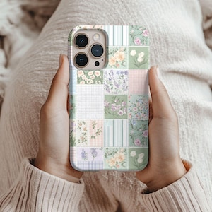 May include: A smartphone case featuring a patchwork design of various squares. The patterns include light green and white stripes, soft peach and white floral prints, lavender sprigs, white grid paper, and small pink and purple flower clusters.