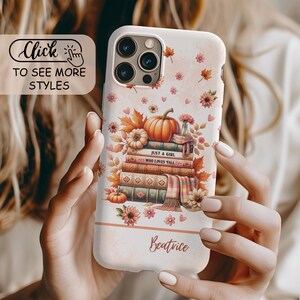 May include: A white smartphone case featuring a stack of books topped with a pumpkin, autumn leaves, and flowers. The text reads JUST A GIRL WHO LOVES FALL and the name Beatrice. The design includes small hearts and a plaid scarf draped over the books.