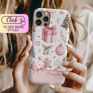 May include: A pink and white phone case with a Christmas theme. The case features a variety of festive designs, including presents, ornaments, and a gingerbread man. The name "Jennifer" is printed on the bottom of the case.