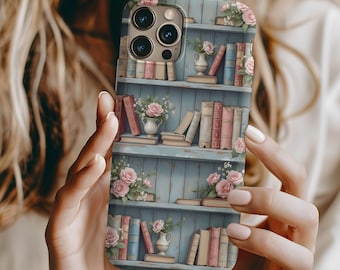 May include: A blue and white phone case with a bookshelf design featuring books, flowers, and a vase. The case has a camera lens cutout and a floral pattern.