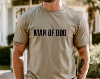 May include: Khaki-colored t-shirt with the text "MAN OF GOD" printed in black. The shirt is short-sleeved and appears to be made of a soft material. The word "KHAKI" is displayed in a white box at the bottom of the image.