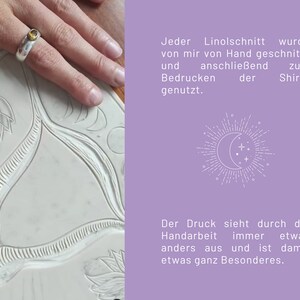 May include: A close-up of a hand carving a linoleum block with a tool. The block has a floral design carved into it. The text "Jeder Linolschnitt wurde von mir von Hand geschnitzt und anschlie&szlig;end zum Bedrucken der Shirts genutzt." is visible in the background.