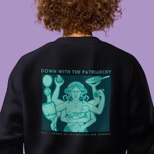 Könnte beinhalten: Schwarzes Sweatshirt mit einem Grafikdruck einer Frau mit mehreren Armen, die verschiedene Gegenstände halten. Der Text "DOWN WITH THE PATRIARCHY" ist über dem Grafikdruck gedruckt. Der Text "KALI - GODDESS OF DESTRUCTION AND RENEWAL" ist unter dem Grafikdruck gedruckt.
