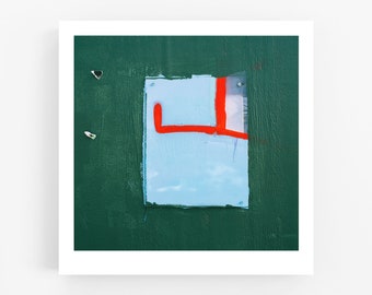 May include: A blue and red abstract painting on a green background. The painting is a rectangle with a red line across it. The line is broken in the middle and the two ends are connected by a smaller red line.