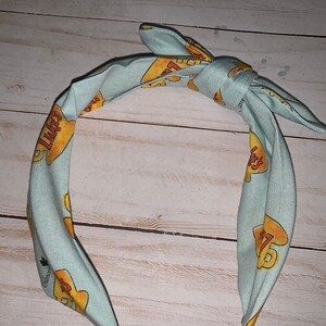 May include: A light blue headband with a yellow and orange print of the text "Like" and a number "17".