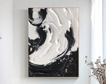 May include: Abstract painting with black and white swirls and strokes. The painting is framed in a thin gold frame.