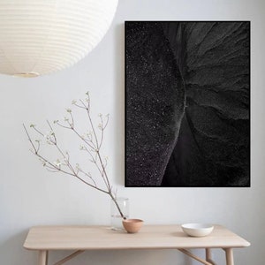 Puede incluir: Una fotograf&iacute;a en blanco y negro de un paisaje rocoso. La imagen est&aacute; enmarcada y colgada en una pared blanca sobre una mesa de madera.
