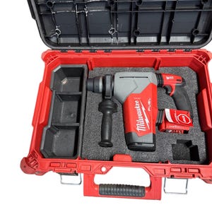 May include: A red and black hard-shell case with a gray and red power tool inside. The tool has a black handle and a battery pack. The case is open, revealing a black interior with compartments for the tool and accessories.