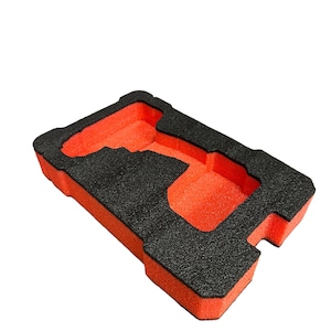 May include: Orange foam insert with a black cutout for a drill. The insert is designed to fit inside a carrying case.