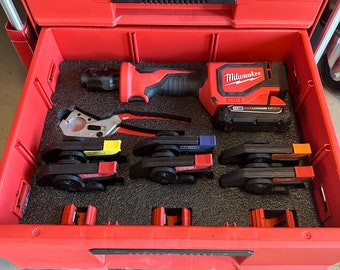 May include: Red Milwaukee Packout tool box with a black foam insert. The box contains a Milwaukee M18 FUEL 1/2-inch drive impact wrench, a pipe cutter, and four black and red pipe cutters.