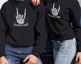May include: Two black sweatshirts with a white skeleton hand making a rock and roll hand gesture. The text "Elder Emo" is printed on each sweatshirt.