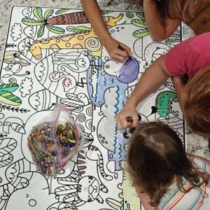Pu&ograve; includere: Un grande poster da colorare in carta bianca con contorni neri di vari animali, tra cui una giraffa, ippopotami e un leone, accompagnato da un sacchetto di plastica trasparente pieno di pastelli a cera colorati assortiti per attivit&agrave; creative.