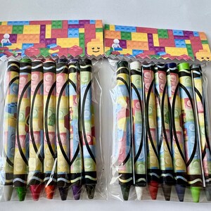 May include: Two packages of colorful crayons with a Lego-themed design. Each package contains 8 crayons with a variety of colors.
