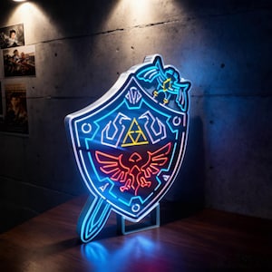 May include: A neon light shield with a sword-shaped handle. The shield features a blue outline with a red and yellow emblem. The light is on a wooden surface with a concrete wall background.