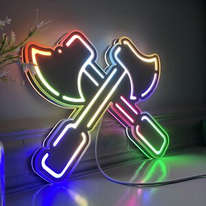 May include: A neon sign shaped like two crossed axes, with each axe glowing in a different color of the rainbow.