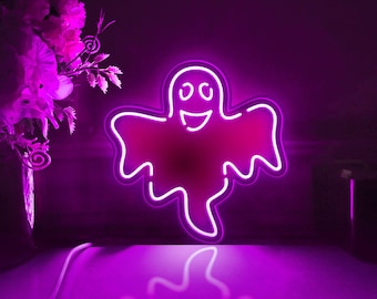 May include: A purple neon light shaped like a ghost with a smiling face. The light is on a dark purple surface.
