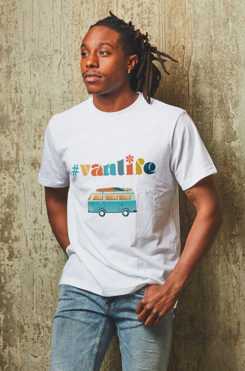 Puede incluir: Camiseta blanca con un gr&aacute;fico de furgoneta azul y blanca y el texto "#vanlife" en letras de colores.