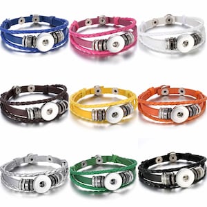 Könnte beinhalten: Neun geflochtene Lederarmbänder mit Druckknopfverschluss. Die Armbänder sind in Blau, Rosa, Weiß, Braun, Gelb, Orange, Grau, Grün und Schwarz erhältlich.